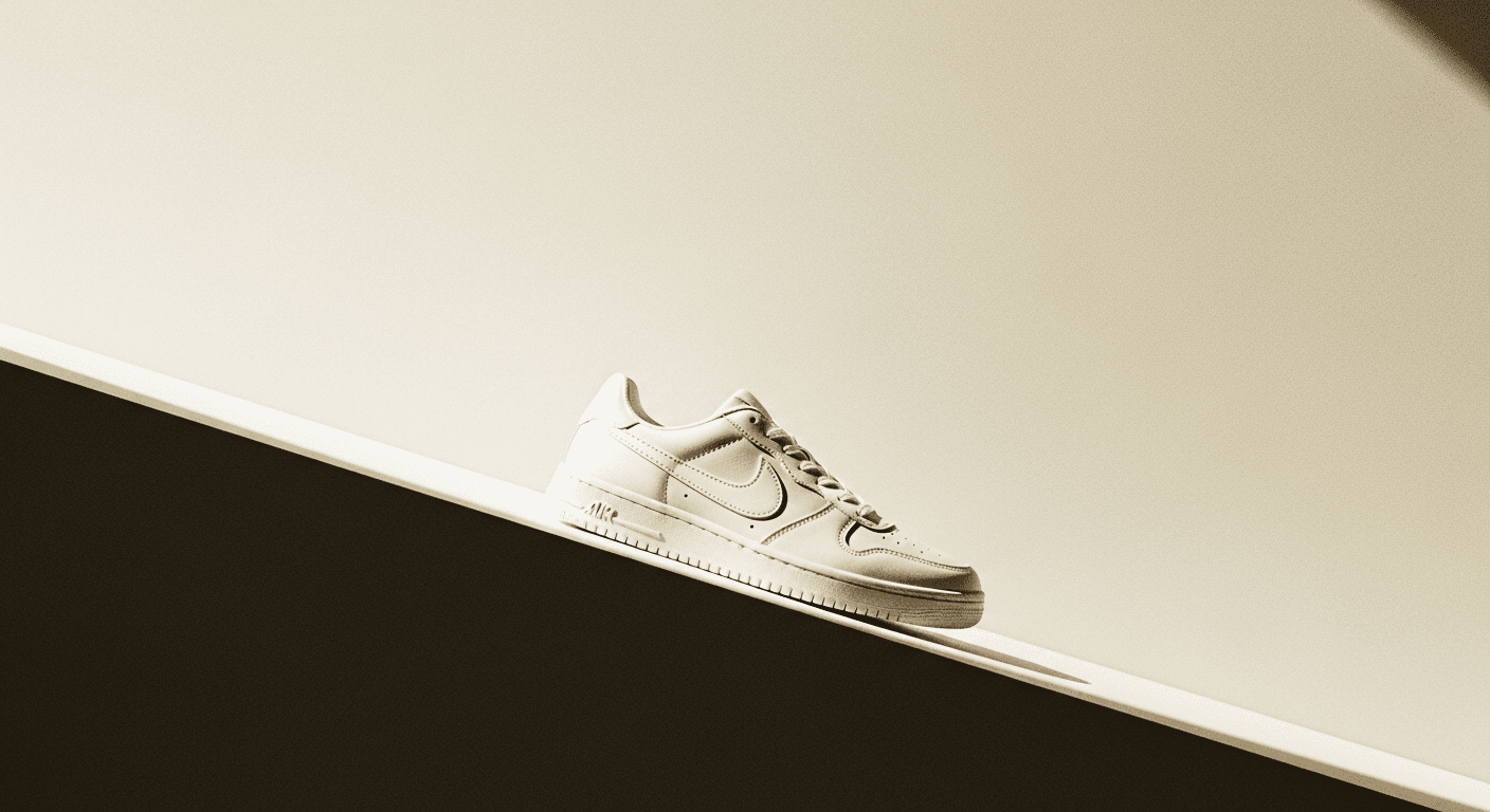 A white premium athletic sneaker angled downward on a minimal cream background, symbolizing market decline.